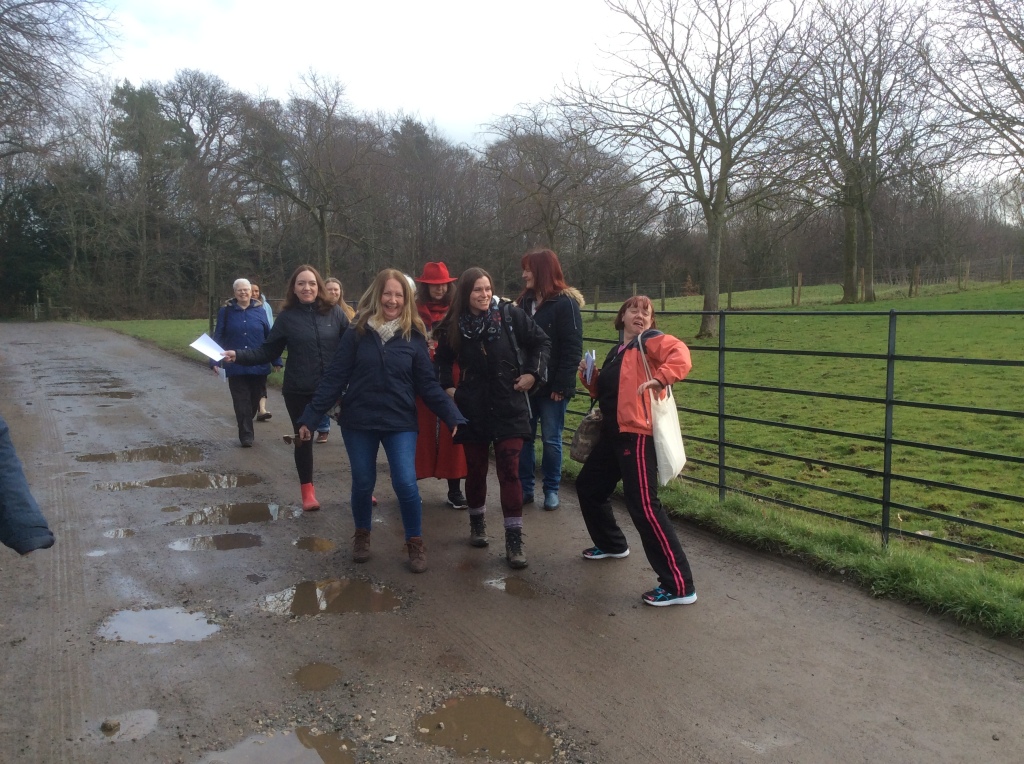 A group of women walking through a country estate, pulling silly poses